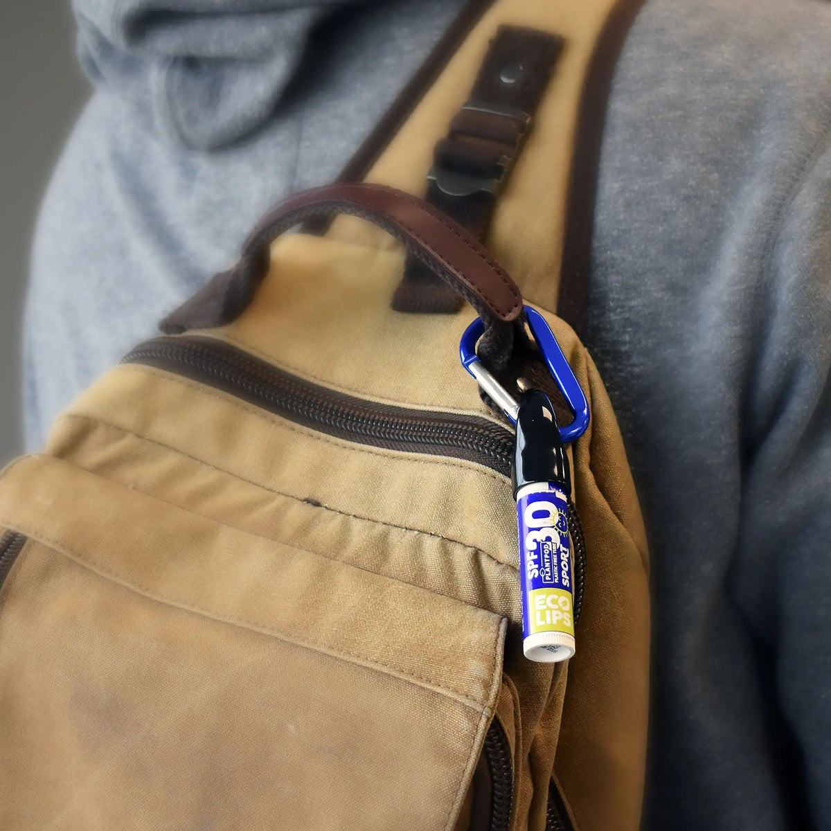 Image of spf 30 lip balm with carabiner attached to the handle on a backpack 