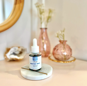A customer is holding the nighttime serum and applying the dropper to her cheek 