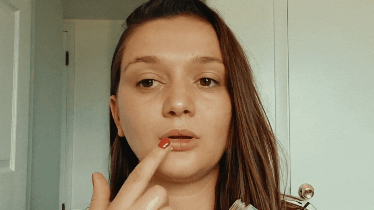 Woman applying lip scrub to her lips. 