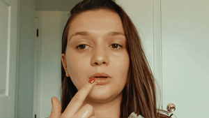 Eco-friendly lip balm advertisement with certification logos on a red background.